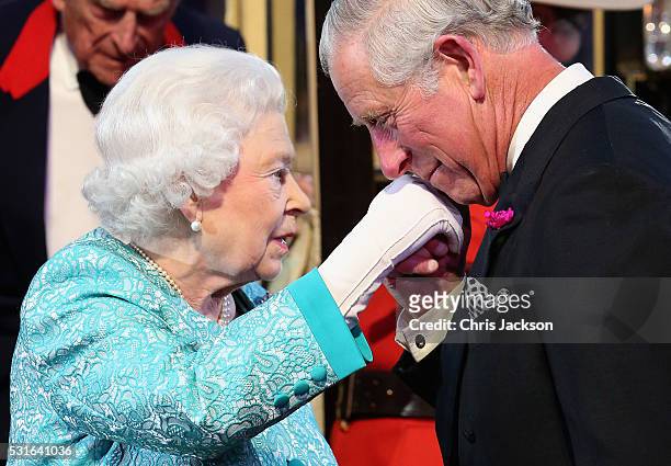 Queen Elizabeth II is greeted by Prince Charles, Prince of Wales as she arrives for the final night of her 90th Birthday Celebrations at Windsor on...