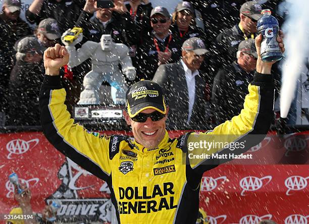 Matt Kenseth, driver of the Dollar General Toyota, celebrates in Victory Lane after winning the NASCAR Sprint Cup Series AAA 400 Drive for Autism at...