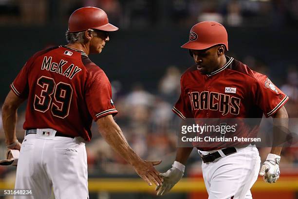 Michael Bourn of the Arizona Diamondbacks high-fives first base coach Dave McKay after a sacrifice bunt against the San Francisco Giants during the...