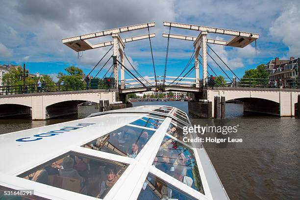 drawbridge across canal seen from sightseeing boat - amsterdam mensen boot stockfoto's en -beelden
