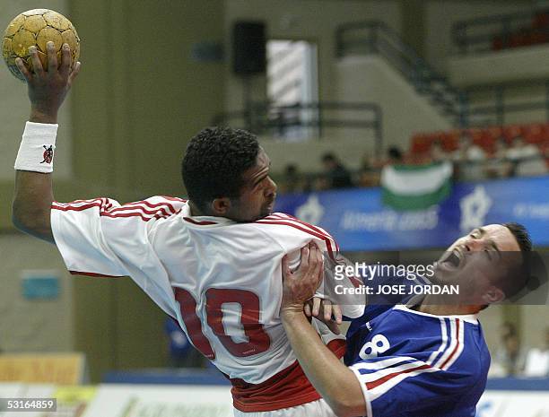 Spain: French Benoit Henry vies with Ali Madi from Tunisia during their handball match of the XV Mediterranean Games, 29 June 2005 in Roquetas de...