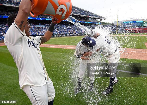 Kendrys Morales of the Kansas City Royals and catching coach Pedro Grifol are doused with water by Salvador Perez as they celebrate a 4-2 win against...