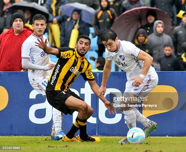 Maximiliano Olivera of Peñarol and Jorge Fucile of Nacional fight for the ball during a match between Peñarol and Nacional as part of Torneo Clausura...