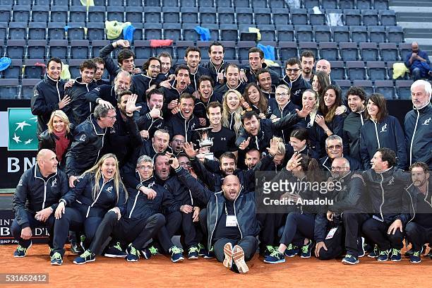 Andy Murray of England poses with tennis court crew as he holds his trophy after winning the Men's Singles Final match against Novak Djokovic during...
