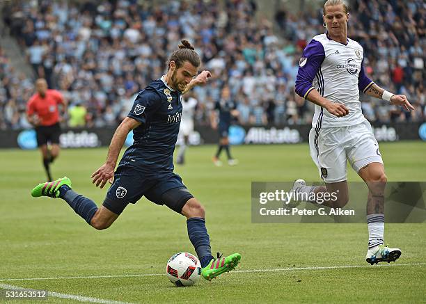 Forward Graham Zusi of Sporting Kansas City attempts a shot on goal against forward Brek Shea of Orlando City SC during the second half on May 15,...