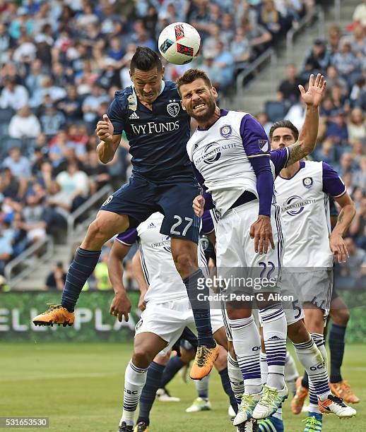 Mid-fielder Roger Espinoza of Sporting Kansas City heads the ball on goal against defender Antonio Nacerino of Orlando City SC during the second half...