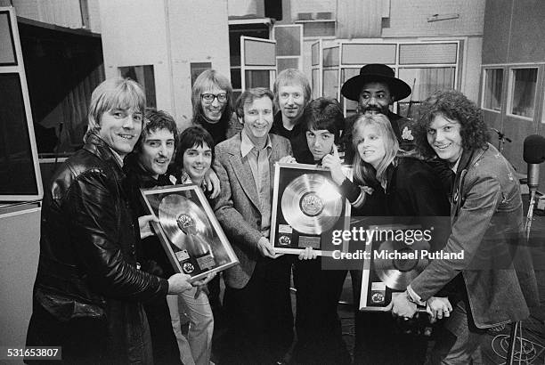British rock group Wings and others pose with platinum discs for the Wings album 'Band On The Run', at Abbey Road Studios, London, 15th November...