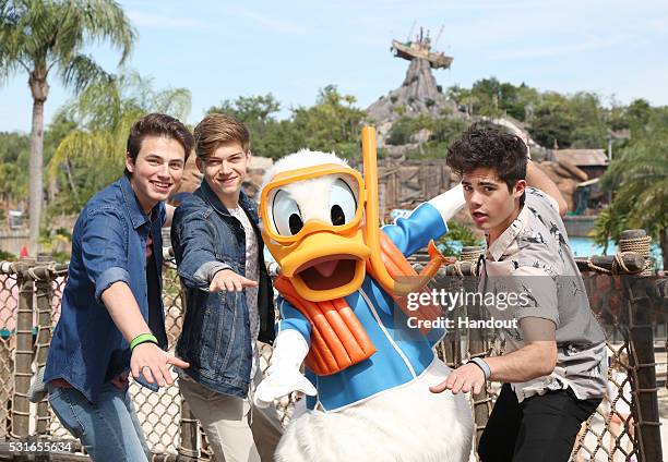 Emery Kelly, Liam Attridge and Ricky Garcia of the music group Forever in Your Mind join Donald Duck at Disney's Typhoon Lagoon at the Walt Disney...