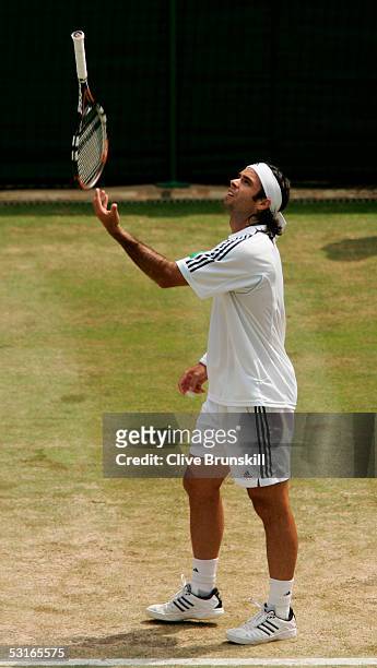 Fernando Gonzalez of Chile throws his racquet in the air in his match against Roger Federer of Switzerland in the Gentlemen?s Singles during the...