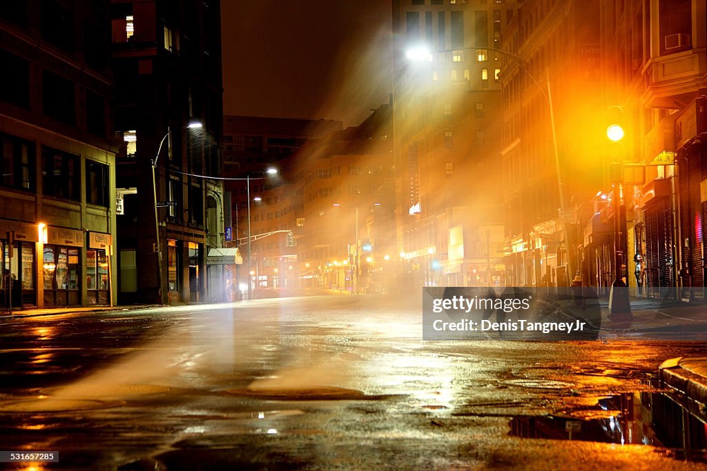 Steam rising from manhole cover on city street