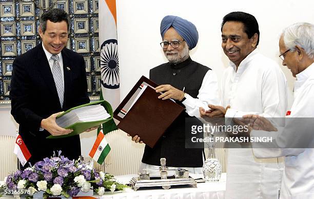 Indian Commerce Minister, Kamal Nath and Foreign Minister, Natwar Singh applaud as Singapore Prime Minister, Lee Hsien Loong exchanges the Annexure...