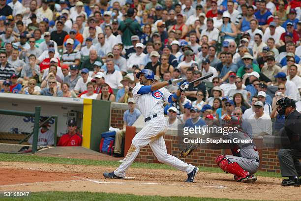 Derrek Lee of the Chicago Cubs bats as Jason Varitek of the Boston Red Sox catches and umpire Ed Montague looks on during the game against at Wrigley...