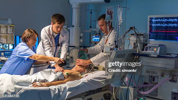 doctors and nurse in operating theatre - defibrillation stock pictures, royalty-free photos & images