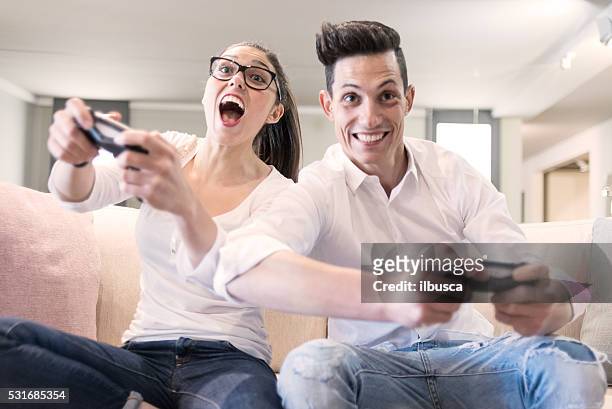 couple playing videogames in the living room - fighting game stock pictures, royalty-free photos & images