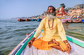 Sadhu is meditating in boat on Holy Ganges River, Varanasi