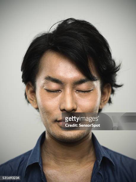 portrait of a young japanese man with closed eyes. - man smiling eyes closed stock pictures, royalty-free photos & images