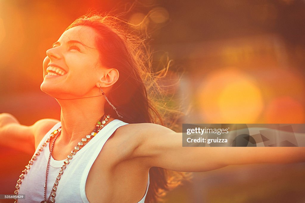 Mujer joven brazos estirados disfruta de la libertad y de aire fresco
