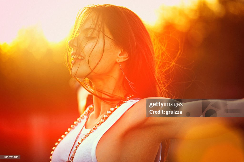 Young woman outstretched arms enjoys the freedom and fresh air