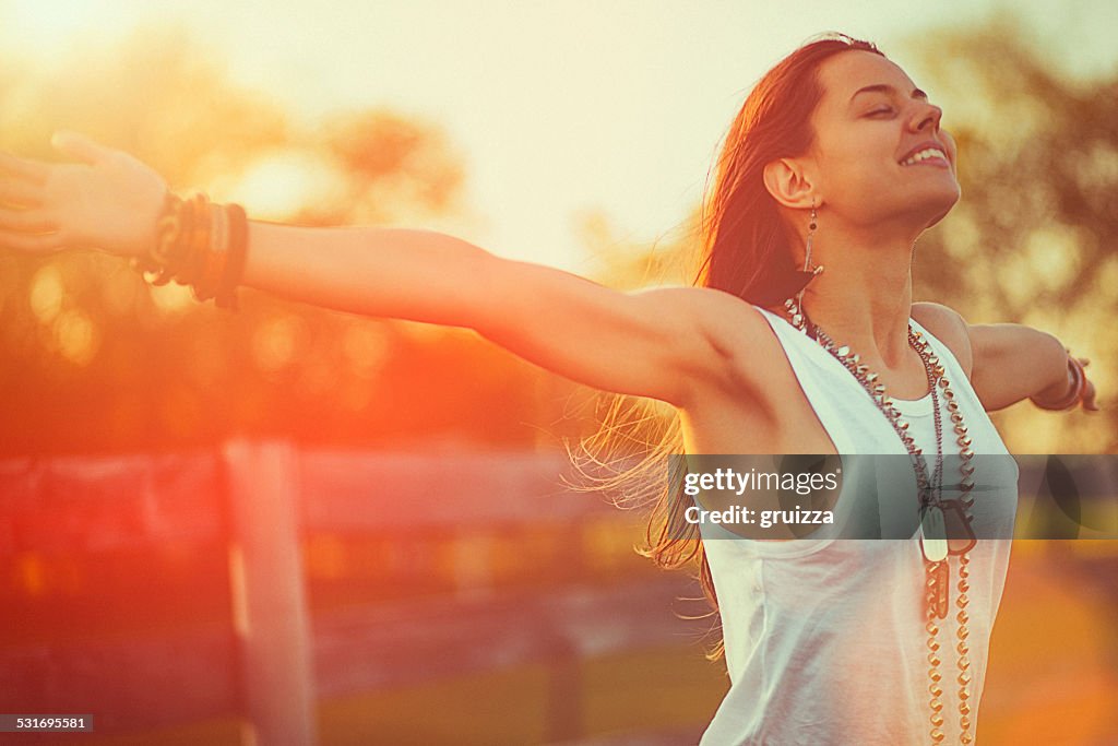 Young woman outstretched arms enjoys the freedom and fresh air