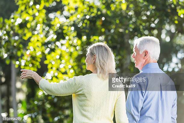 senior couple in the park, walking, holding hands - old point comfort stock pictures, royalty-free photos & images