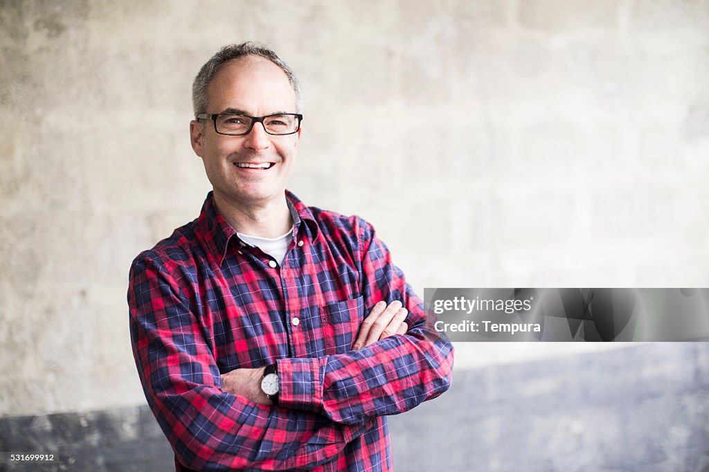 Middle aged man smiling and looking at camera.