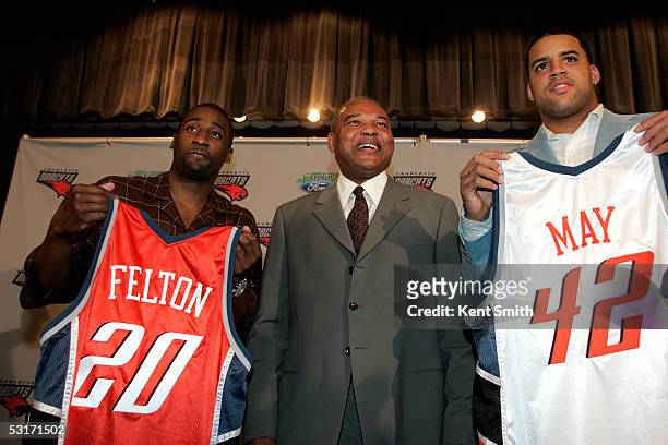 Raymond Felton and Sean May of the Charlotte Bobcats hold up their new jerseys with general manager and head coach Bernie Bickerstaff during a press...