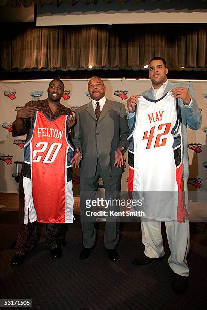 Raymond Felton and Sean May of the Charlotte Bobcats hold up their new jerseys with general manager and head coach Bernie Bickerstaff during a press...