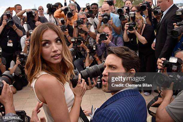 Ana de Armas uses a photographer's camera as Edgar Ramirez looks on during the "Hands Of Stone" photocall during the 69th annual Cannes Film Festival...