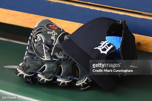 Detailed view of the baseball hat, Oakley sunglasses and Wislon baseball glove worn by J.D. Martinez of the Detroit Tigers sitting in the dugout...