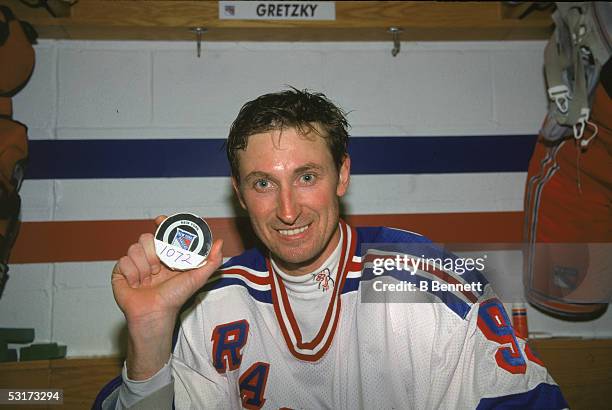 Wayne Gretzky of the New York Rangers, holds up the puck with which he scored his 1072nd goal in the locker room of Madison Square Garden, New York,...