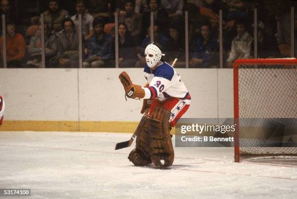 American hockey player Jim Craig, goalkeeper for Team USA, stick out his glove to make a save in an exhibition game against the Soviet team at...