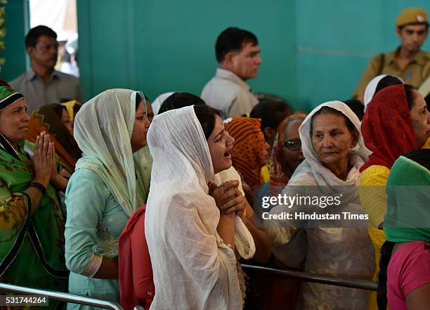 Grieving devotees stand in line to pay their last respects to mortal remains of Baba Hardev Singh, spiritual leader of the Sant Nirankari Mission,...