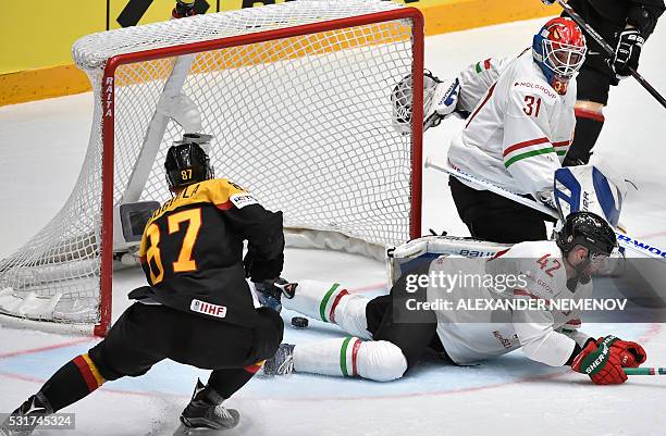 Hungary's goalie Miklos Rajna eyes the puck sliding into his net as Hungary's defender Marton Vas tries to stop it during the group B preliminary...