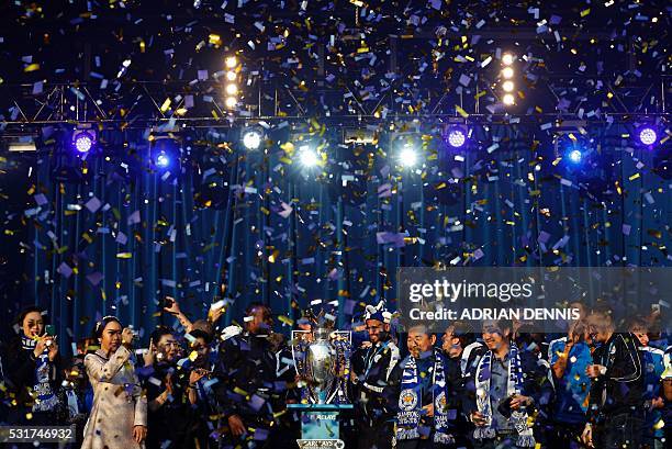 Ticker-tape falls onto the Leicester City football team as they stand with the Premier league trophy during a victory celebration in front of fans in...