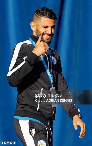 Leicester City's Algerian midfielder Riyad Mahrez gestures to fans as he arrives on stage to pase with teammates and the Premier league trophy as the...