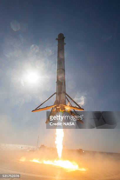 In this handout provided by the National Aeronautics and Space Administration , SpaceX's Falcon 9 rocket makes its first successful upright landing...