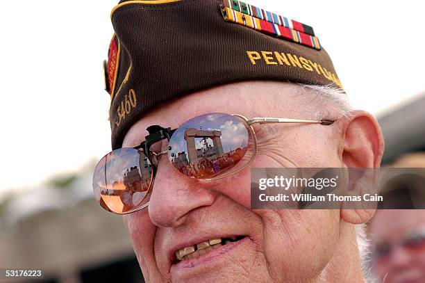 Angelo Marsella, of Brookhaven, Pennsylvania watches as the USS Cole, which is reflected in his glasses, enters port June 30, 2005 in Philadelphia,...