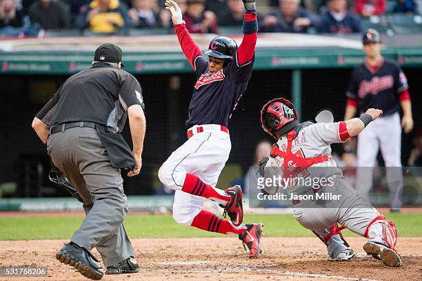 Home plate umpire Paul Emmel watches as catcher Ramon Cabrera of the Cincinnati Reds misses the tag as Rajai Davis of the Cleveland Indians scores on...