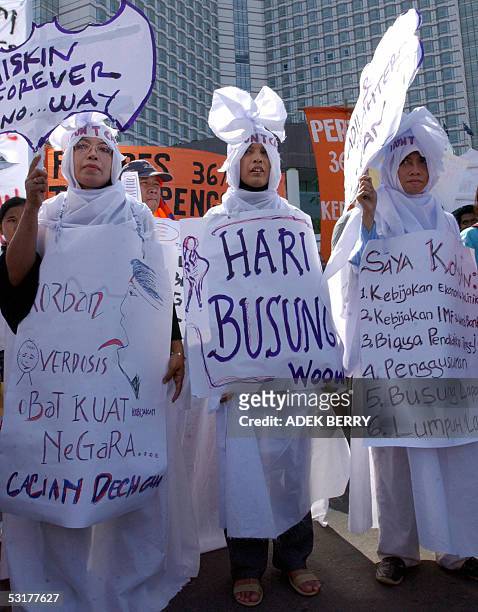 Women wrapped in white cloth symbolising "death" march during a protest in Jakarta, 01 July 2005. Protesters held a demonstration to mark...