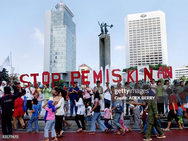 Women hold banner that reads "stop Poverty" during a protest in Jakarta, 01 July 2005. Protesters held a demonstration to mark International White...