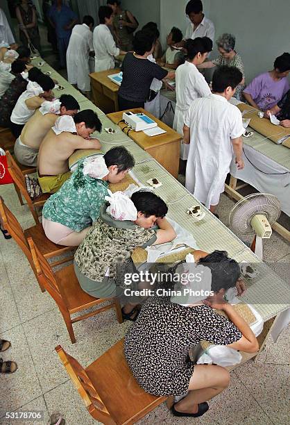 Chinese people undergo treatment by applying Chinese salve at the Shanghai Shuguang Hospital on June 30, 2005 in Shanghai, China. The method of...