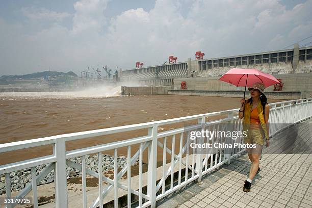 Tourist walks at the Three Gorges Dam on the day it opened to the public July 1, 2005 in Yichang, Hubei Province, central China. When completed, the...