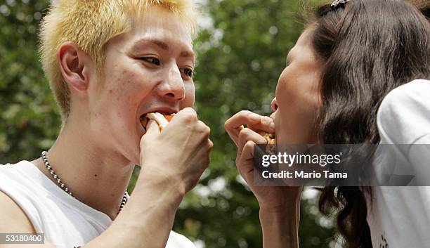 Takeru Kobayashi of Japan and Sonya Thomas of Alexandria, VA eat hot dogs during the ceremonial weigh-in for the 90th installment of the Nathan's...