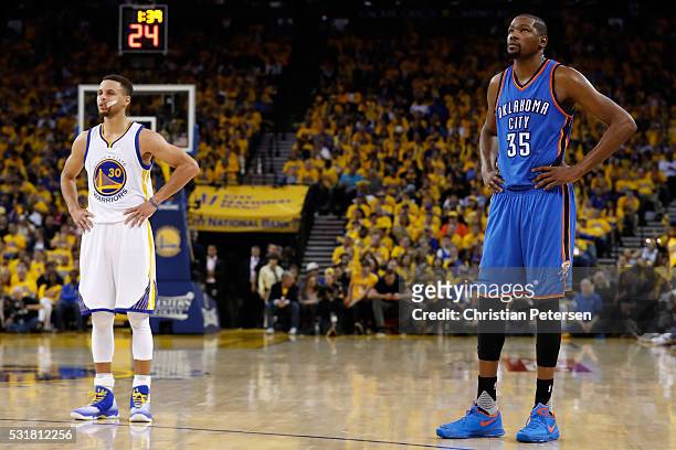 Stephen Curry of the Golden State Warriors and Kevin Durant of the Oklahoma City Thunder stand on the court during game one of the NBA Western...