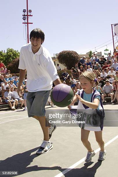Andrew Bogut of the Milwaukee Bucks coaches a young fan during a relay race at Summerfest on June 30, 2005 in Milwaukee, Wisconsin. NOTE TO USER:...