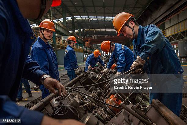 Workers maintain the production line at the Zhong Tian Steel Group Corporation on May 12, 2016 in Changzhou, Jiangsu. Zhong Tian Steel Group...