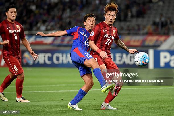 Japan's FC Tokyo midfielder Naotake Hanyu shoots beside China's Shanghai SPIG defender Shi Ke during the AFC champions league round of 16 first match...