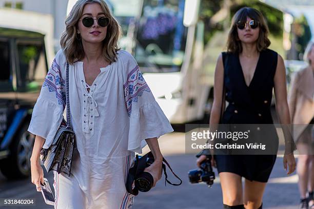 Fashion blogger Carmen Hamilton wearing a white tunic dress and a Gucci bag and Talisa Sutton wearing a sleeveless dress with golden buttons with...