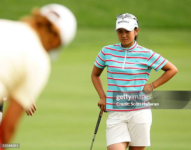 Ai Miyazato of Japan watches Sophie Gustafson of Sweden putt on the eighth green during her match with Gustafson during the third round of the HSBC...