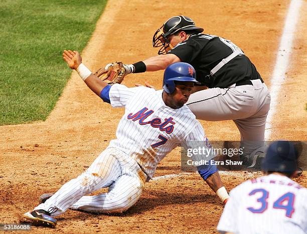 Jose Reyes of the New York Mets slides safely past catcher Matt Treanor of the Florida Marlins to give the Mets a 3-1 lead in the fifth inning on...